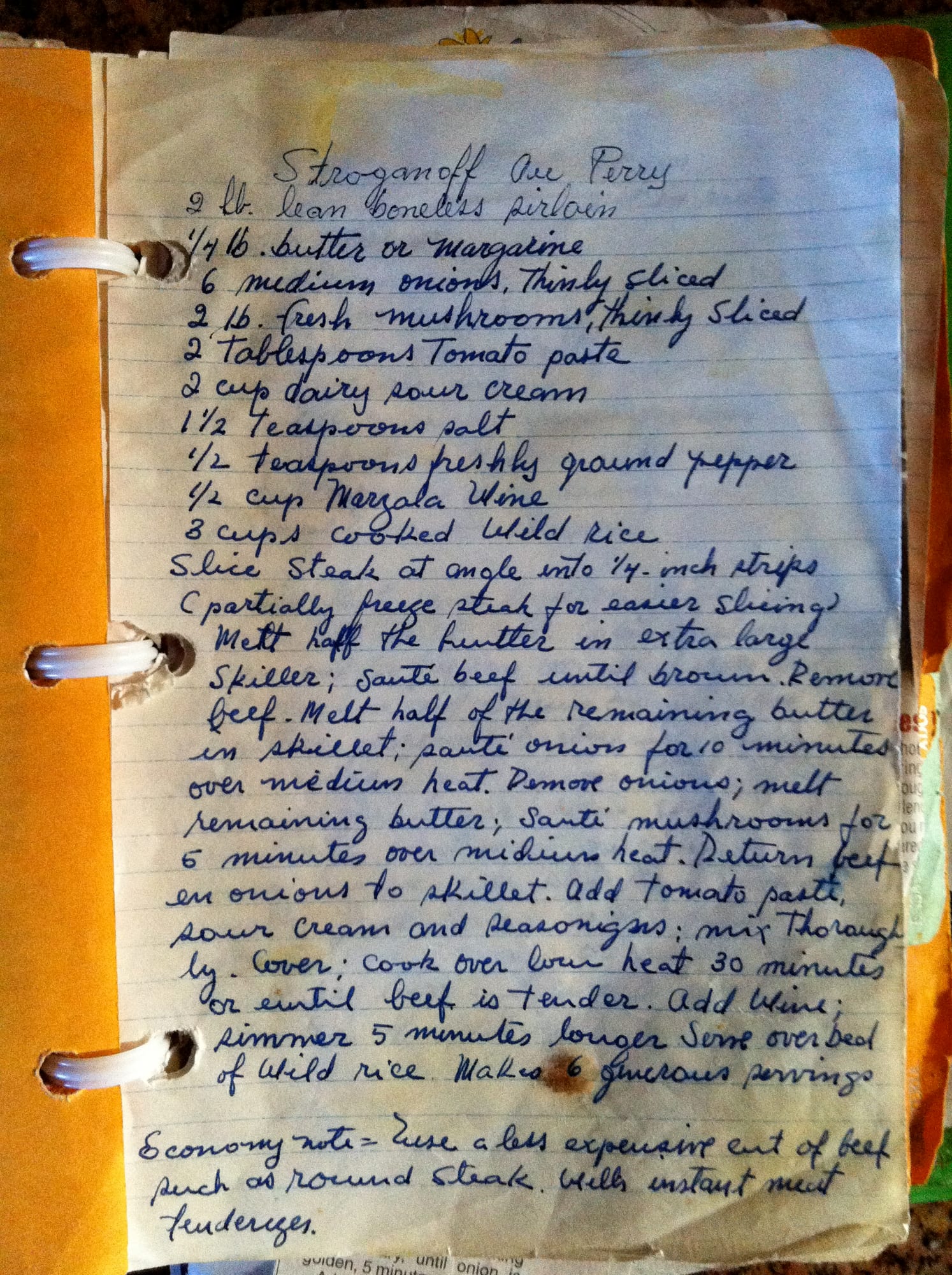 The handwritten Stroganoff Au Perry recipe card, in blue ink on lined paper, held in a ring binder